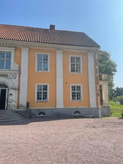 Slottets gula fasad med entré och trappa